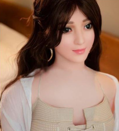 Close-up of a person wearing a beige top with a blurred background